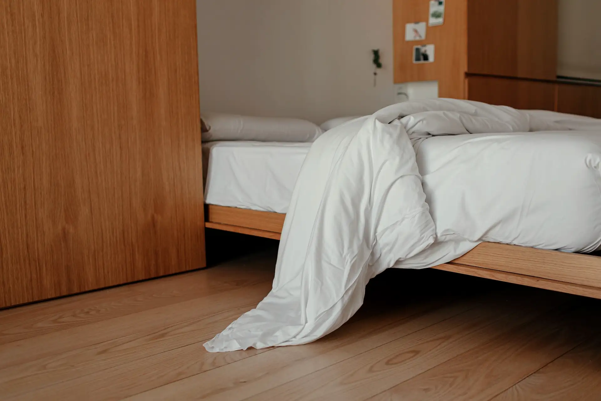 Sobere kamer met een houten bed en wit beddengoed